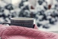 Winter morning. Cup with hot drink wrapped in pink sweater outdoors, closeup. Space for text Royalty Free Stock Photo