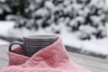 Winter morning. Cup with hot drink wrapped in pink sweater outdoors, closeup. Space for text Royalty Free Stock Photo