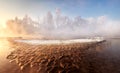 Winter morning frosty scenery with a small forest river and brown sandy shallows, similar to lava. Royalty Free Stock Photo