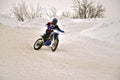 Winter motocross racer on a motorcycle turns with the slope and Royalty Free Stock Photo