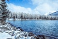 Winter mountain lake with snow-covered pine trees on the shore. Royalty Free Stock Photo