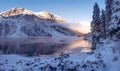 Winter mountain landscape. Beautiful ice lake in mountains. Scenery winter. Fir trees on snowy river shore. Wild nature landscape