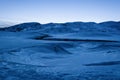 Winter mountain landscape. Frozen lake covered with snow and ice at blue hour. Dam Belmeken in winter, Bulgaria Royalty Free Stock Photo