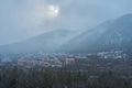 Winter mountain landscape. Small town between mountains. A cloud hangs over the city Royalty Free Stock Photo