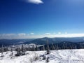 Winter mountain landscape - a snow-white glade, bright sun and snowy trees, branches covered with flakes of hoarfrost. Ski resort