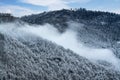 winter mountain landscape. Snowdrifts on winter snow covered mountainside, fir trees on hill top and blue sky Royalty Free Stock Photo