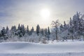 Winter mountain landscape, trees covered with hoarfrost and snow mountains and dramatic clouds in the sky.