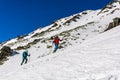 Winter mountain tourism - Ski touring. Mountain rescuer TOPR with the girl during the trip approached skiing slope snow on a
