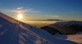 Splendid sunset. Winter mountain landscape. Sun, snow and hikers at high altitude - Ciucas Mountains, landmark attraction, Romania