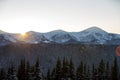 Winter mountains landscape panorama at sunrise. Clear blue sky over dark spruce pine trees forest, covered with snow mountain Royalty Free Stock Photo