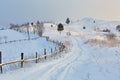 Winter in the mountains. Mountain hills covered with snow. The snowy road goes into the distance near the fence Royalty Free Stock Photo