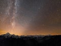 Winter mountains night landscape panorama. Milky Way bright constellation in dark starry sky, soft glow on horizon after sunset, Royalty Free Stock Photo