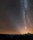 Winter mountains night landscape panorama. Milky Way bright constellation in dark starry sky, soft glow on horizon after sunset, Royalty Free Stock Photo