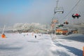 Winter mountains panorama with ski slopes and ski lifts, sunny day with fog and sun rays Royalty Free Stock Photo