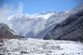 Winter and mountains . There is fog at the foot of the mountains . It snowed on the river stones. In winter, the river water