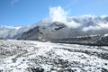 Winter and mountains . There is fog at the foot of the mountains . It snowed on the river stones. In winter, the river water