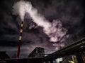 Winter night industrial landscape. Coal-fired power station with smoking chimneys against dramatic dark sky. Air Royalty Free Stock Photo