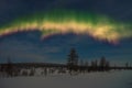 Winter night landscape with forest, cloudy sky and aurora borealis over the taiga Royalty Free Stock Photo