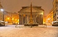 Winter night in Rome with snow blizzard and Pantheon temple church in empty square with golden light , Italy