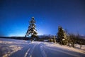 Winter night scenery. Winter road on mountain hills under blue night sky full of stars. Winter mountain nature Royalty Free Stock Photo