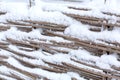 Winter old shabby wobbly wicker fence made of wooden boards. Snow blizzard Royalty Free Stock Photo