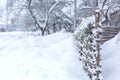 Winter old shabby wobbly wicker fence made of wooden boards. Snow blizzard Royalty Free Stock Photo