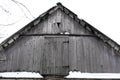 Winter. Old village house, view from the outside of an attic from wooden planks. The roof is covered with snow Royalty Free Stock Photo