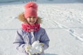 Winter outdoor portrait of child girl smiling and playing with snow, bright sunny winter day Royalty Free Stock Photo