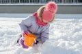 Winter outdoor portrait of child girl smiling and playing with snow, bright sunny winter day Royalty Free Stock Photo