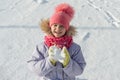 Winter outdoor portrait of child girl smiling and playing with snow, bright sunny winter day Royalty Free Stock Photo