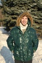 Winter outfit. Man unshaven wear warm jacket with fur snowy nature background. Guy wear winter jacket with furry hood