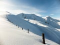 Winter panorama with fence posts and fresh powder of the ridge leading to the Hochwang peak near Chur Royalty Free Stock Photo