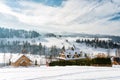 Winter panorama of the mountainous Pieniny village - slopes and roofs of wooden highland houses covered with snow