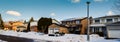 Winter panorama of a row of residential houses along a street, one with solar panels on the roof Royalty Free Stock Photo