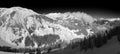 A winter panoramic view Austrian Alps with a black ski slope from the top of the mountain Royalty Free Stock Photo