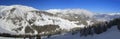 A winter panoramic view Austrian Alps with a black ski slope from the top of the mountain Royalty Free Stock Photo