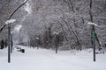 Winter park alley with snowy park benches and street lamp post Royalty Free Stock Photo