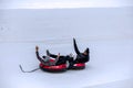 A couple sliding down the hill on tubing sleds