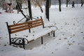 In The Winter Park, An Empty And Lonely Bench Is Completely Covered With Snow. The Snow Is Covered With Leaves That Have Fallen Royalty Free Stock Photo