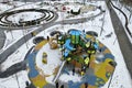 Winter park, square, street with children s playground, covered with snow. Children and adults ride on slides and swings in winter Royalty Free Stock Photo