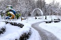 Winter park square street with children s playground, covered with snow. Children`s slides and swings in winter. Dnipro, Royalty Free Stock Photo