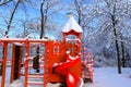 In the winter park, there is red playground covered with snow. Children`s slides and swings in winter. Dnipro city, Dnipropetrovs Royalty Free Stock Photo