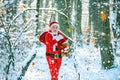 Winter park trees covered with snow. Santa Claus with bag walking in winter. Santa Claus pulling huge bag of gifts on Royalty Free Stock Photo