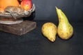 Winter pears brutally brown. Near dried maroon roses. On a dark