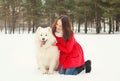 Winter and people concept - happy smiling young woman having fun with white Samoyed dog Royalty Free Stock Photo