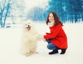 Winter and people - happy smiling young woman owner having fun with white Samoyed dog outdoors Royalty Free Stock Photo