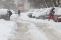 Winter. People walk on a very snowy sidewalk and road. People step on an icy pathway, icy sidewalk. Uncleaned streets and roads