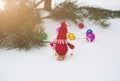 Winter photo with Christmas decorations for pine tree. Knitted snowman toy girl standing on the ski in the forest. Happy holidays Royalty Free Stock Photo