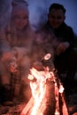 Winter picnic on baech with bonfire. Love story on winter foggy sand beach. fry marshmallows at the stake Royalty Free Stock Photo