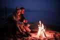 Winter picnic on baech with bonfire. Love story on winter foggy sand beach. fry marshmallows at the stake Royalty Free Stock Photo